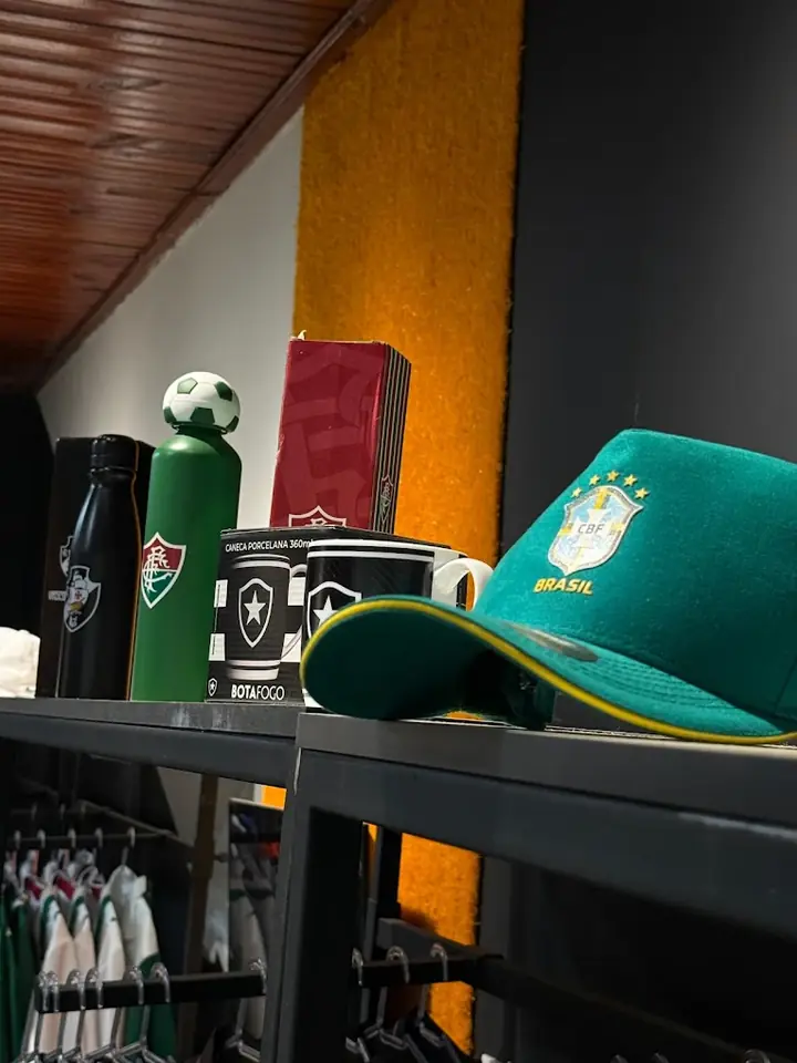 Boné da seleção brasileira, garrafas e canecas de times na prateleira