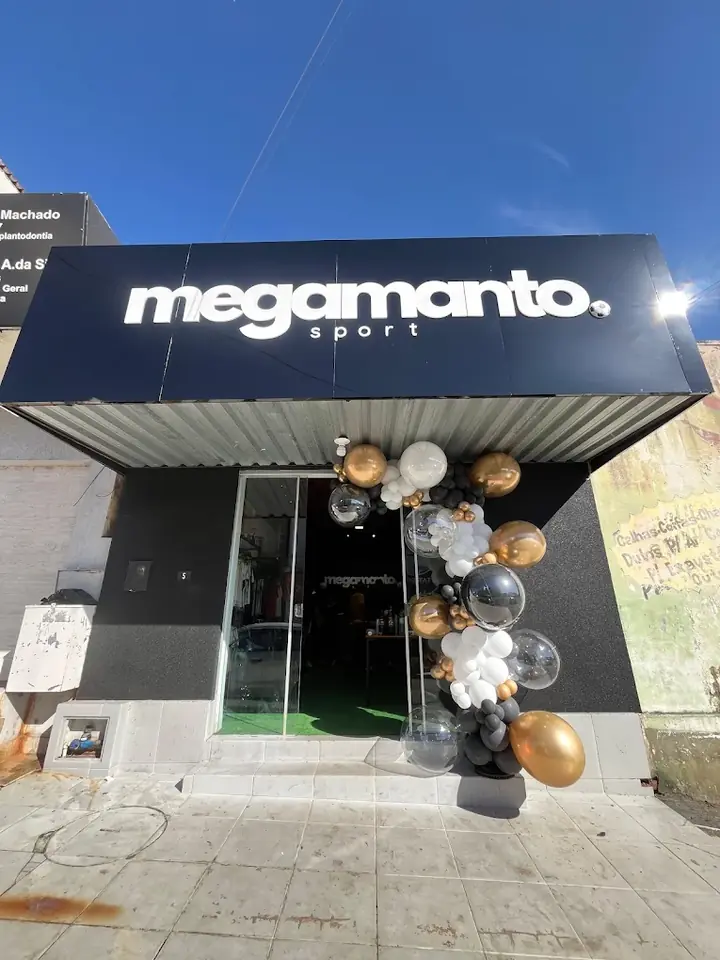 Fachada preta da Mega Manto Sport com o letreiro iluminado